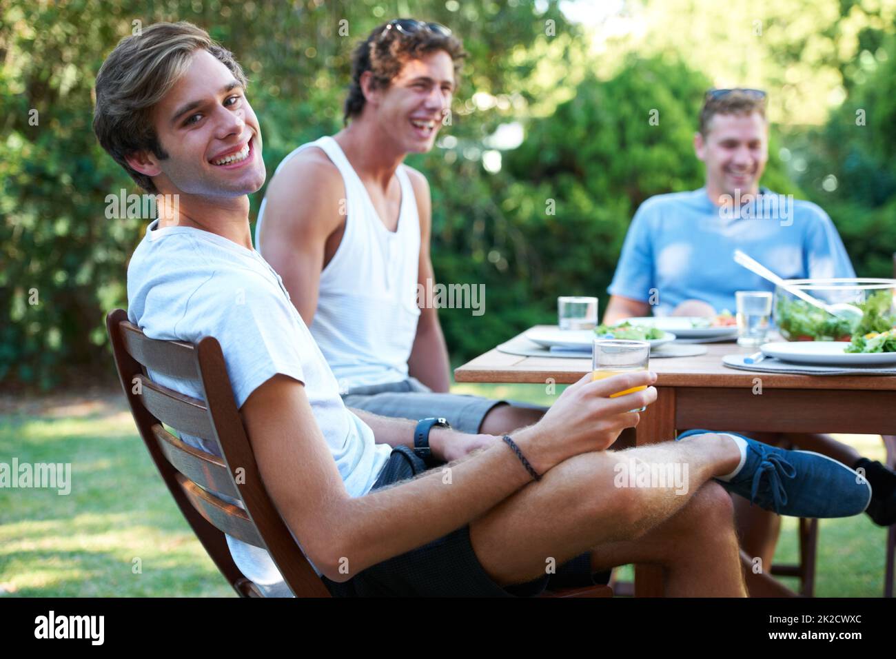 Solo passare il tempo con grandi amici. Sorridendo i giovani a pranzo con un gruppo di amici - ritratto. Foto Stock