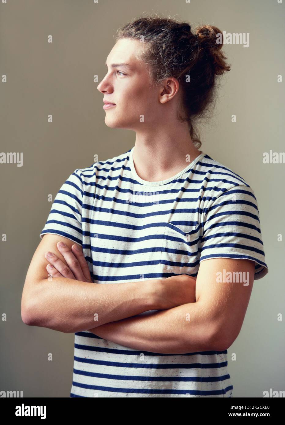 Sensazione di composizione. Profilo girato di un giovane uomo con i capelli in una pistola guardando via. Foto Stock