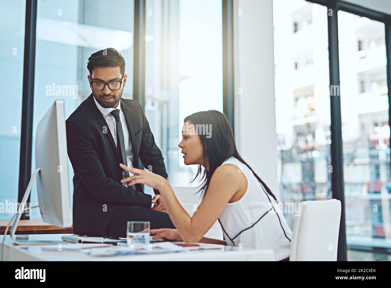 Se si guarda attentamente questo.... Scatto corto di due giovani uomini d'affari che hanno una discussione mentre lavorano su un computer in un ufficio moderno. Foto Stock