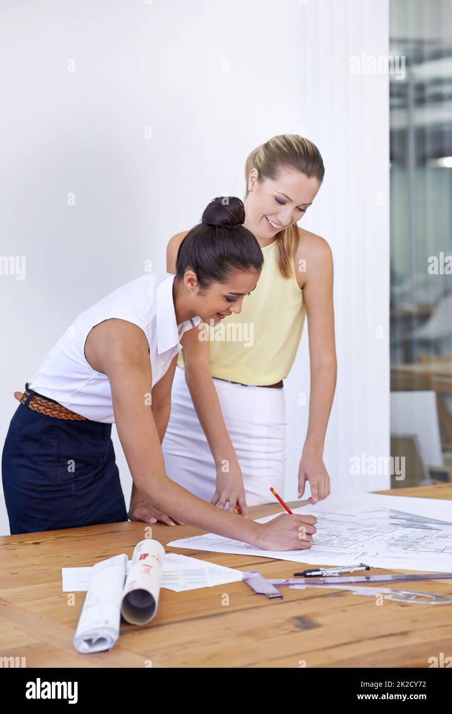 Desiderate che questi 2 progettino il vostro edificio. Due giovani architetti femminili che lavorano su alcuni nuovi progetti. Foto Stock