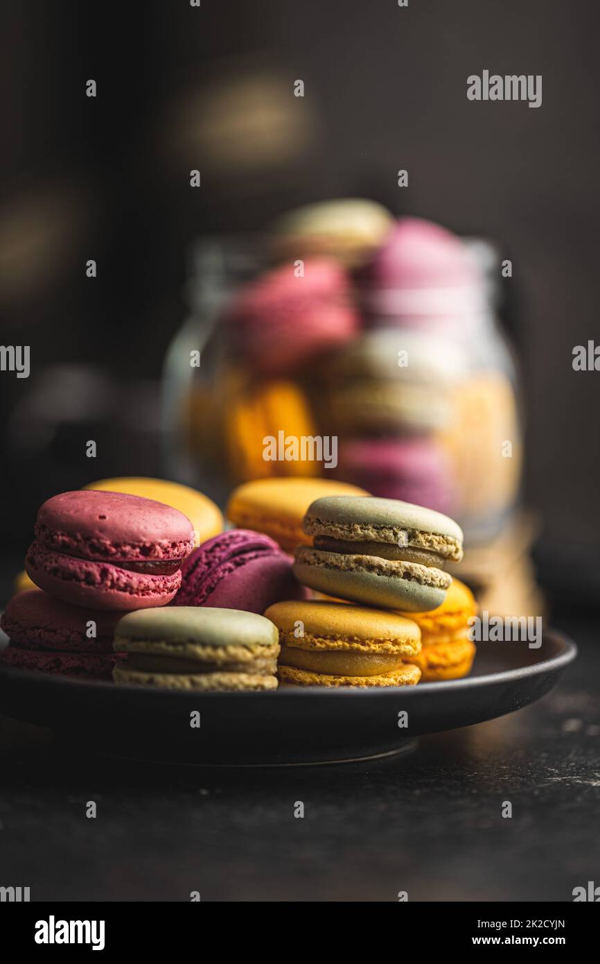 Amaretti colorati e dolci. Macaron francesi tradizionali. Gustoso dessert a piatto. Foto Stock