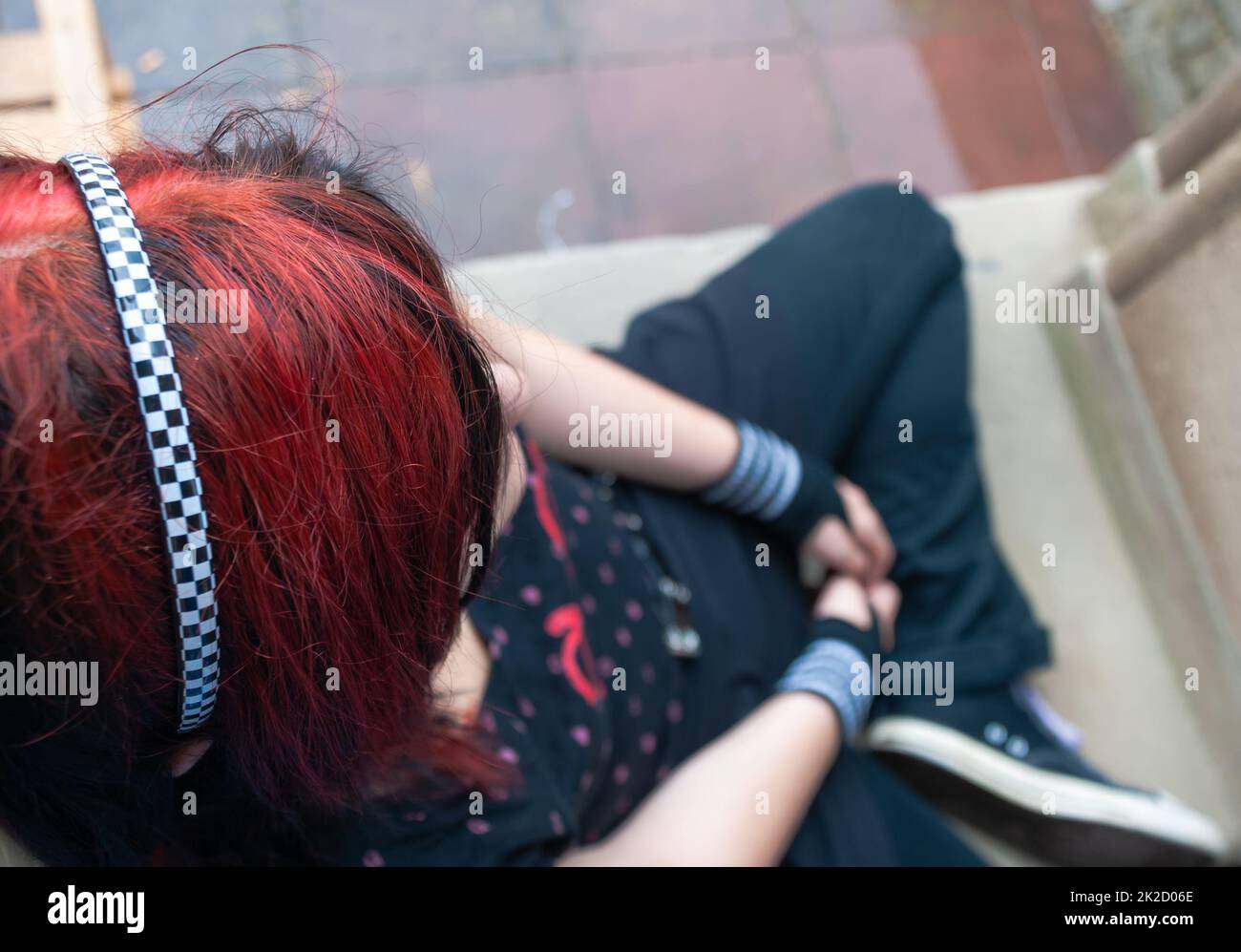 Punk emo ragazza, giovane adulto con capelli neri rossi Foto Stock