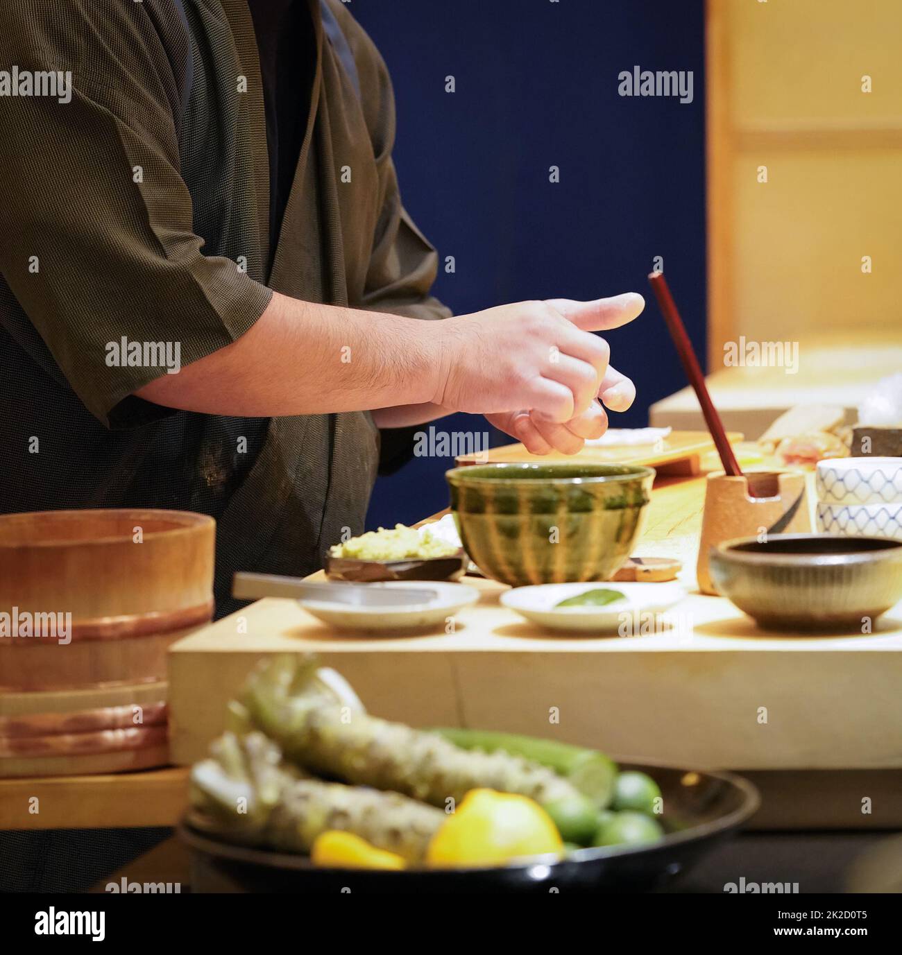 Chef in uniforme nera che prepara il sushi nigiri al sushi bar. Foto Stock