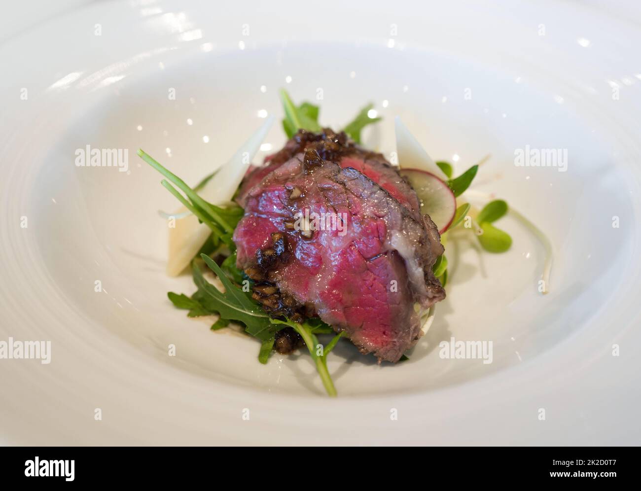 Mini costolette di manzo cotte lentamente servite su piatto bianco. Brunch domenicale, piatto principale. Foto Stock