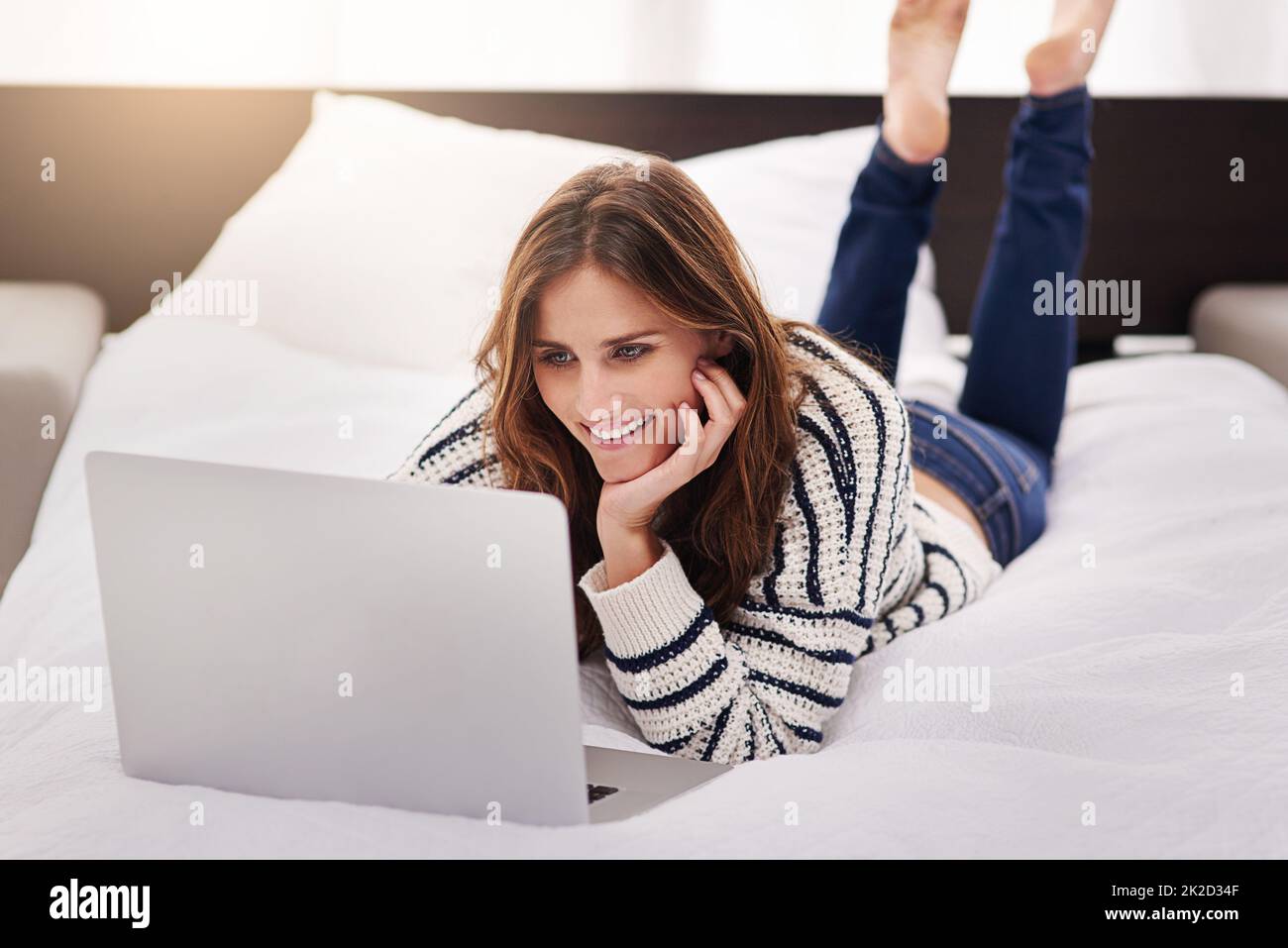 Ama passare il suo tempo libero online. Scatto di una bella giovane donna che naviga su un notebook a casa. Foto Stock