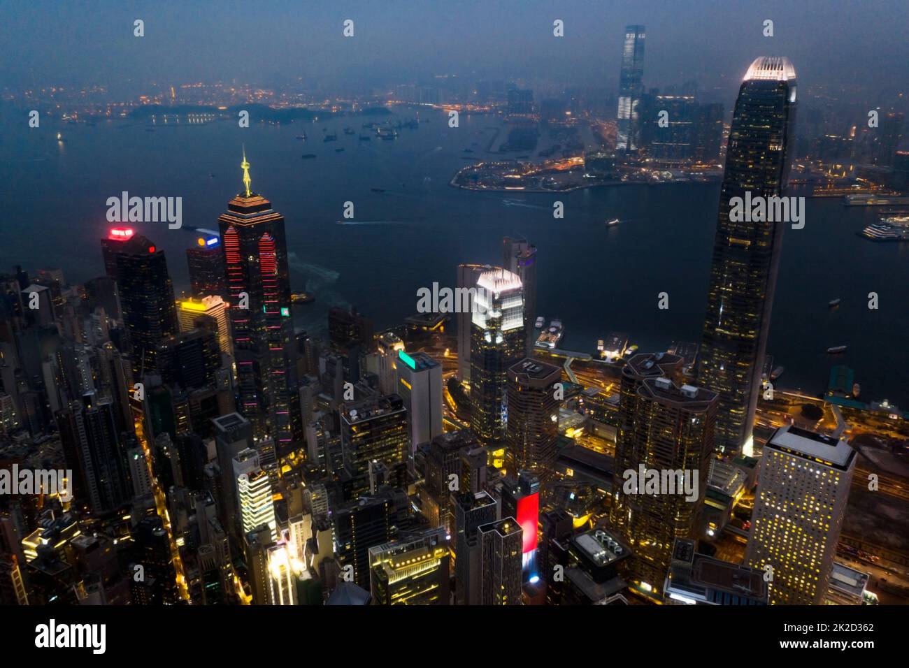 Questa città brilla di notte. Scatto aereo di grattacieli, blocchi di uffici e altri edifici commerciali nella metropoli urbana di Hong Kong. Foto Stock
