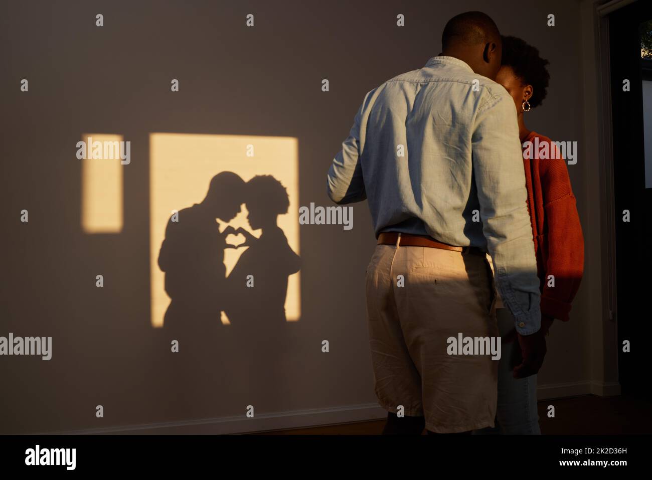 L'amore ci ha portato qui. Scatto di una coppia irriconoscibile in piedi insieme e condividere un momento intimo a casa. Foto Stock