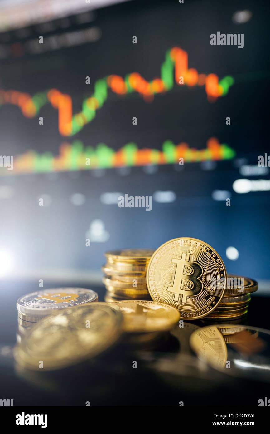 Bitcoins d'oro con grafico a candela e sfondo digitale Foto Stock