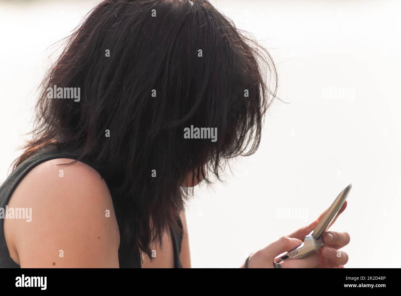 Punk emo ragazza, giovane adulto con capelli neri utilizzando il telefono cellulare Foto Stock