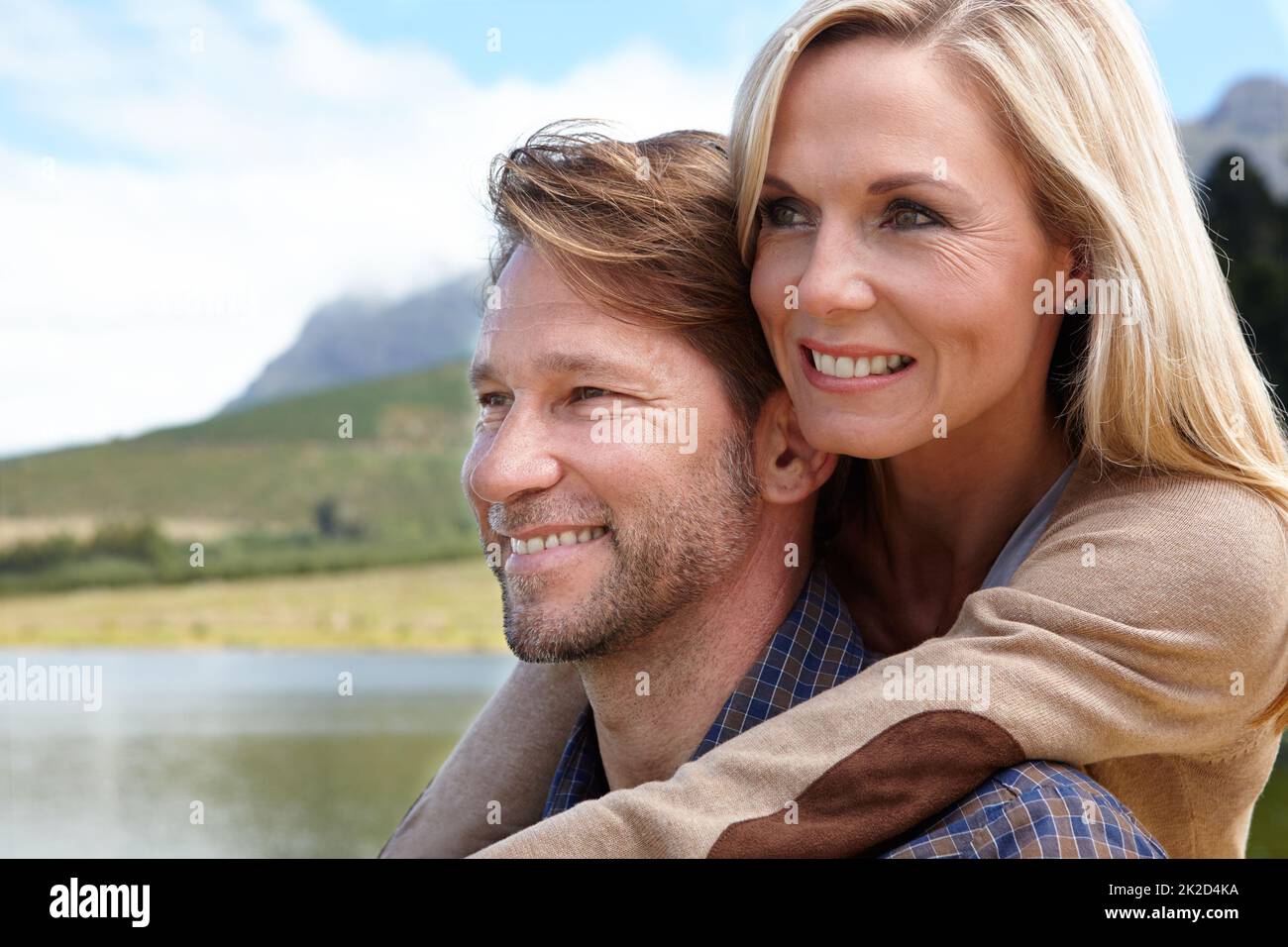 Guardando insieme al futuro. Scatto di una coppia matura amorevole seduta accanto ad un lago in campagna. Foto Stock