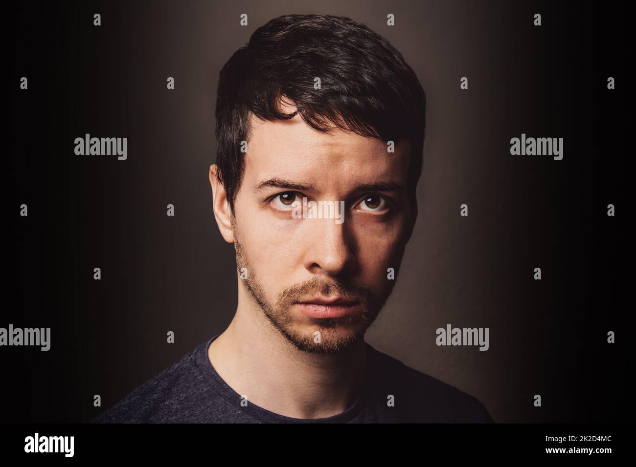 Giovane uomo che guarda la macchina fotografica con emozione negativa Foto Stock