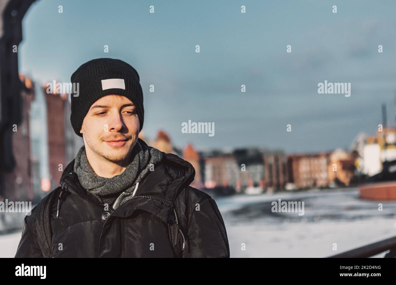 Giovane adulto in piedi con giacca e sciarpa invernali Foto Stock