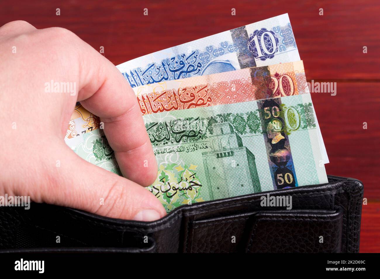 Dinaro libico nel portafoglio nero. Foto Stock