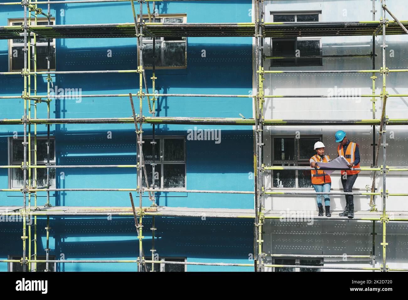 Guarda gli esperti in azione. Scatto di un giovane uomo e una donna che vanno oltre i piani di costruzione in un cantiere. Foto Stock