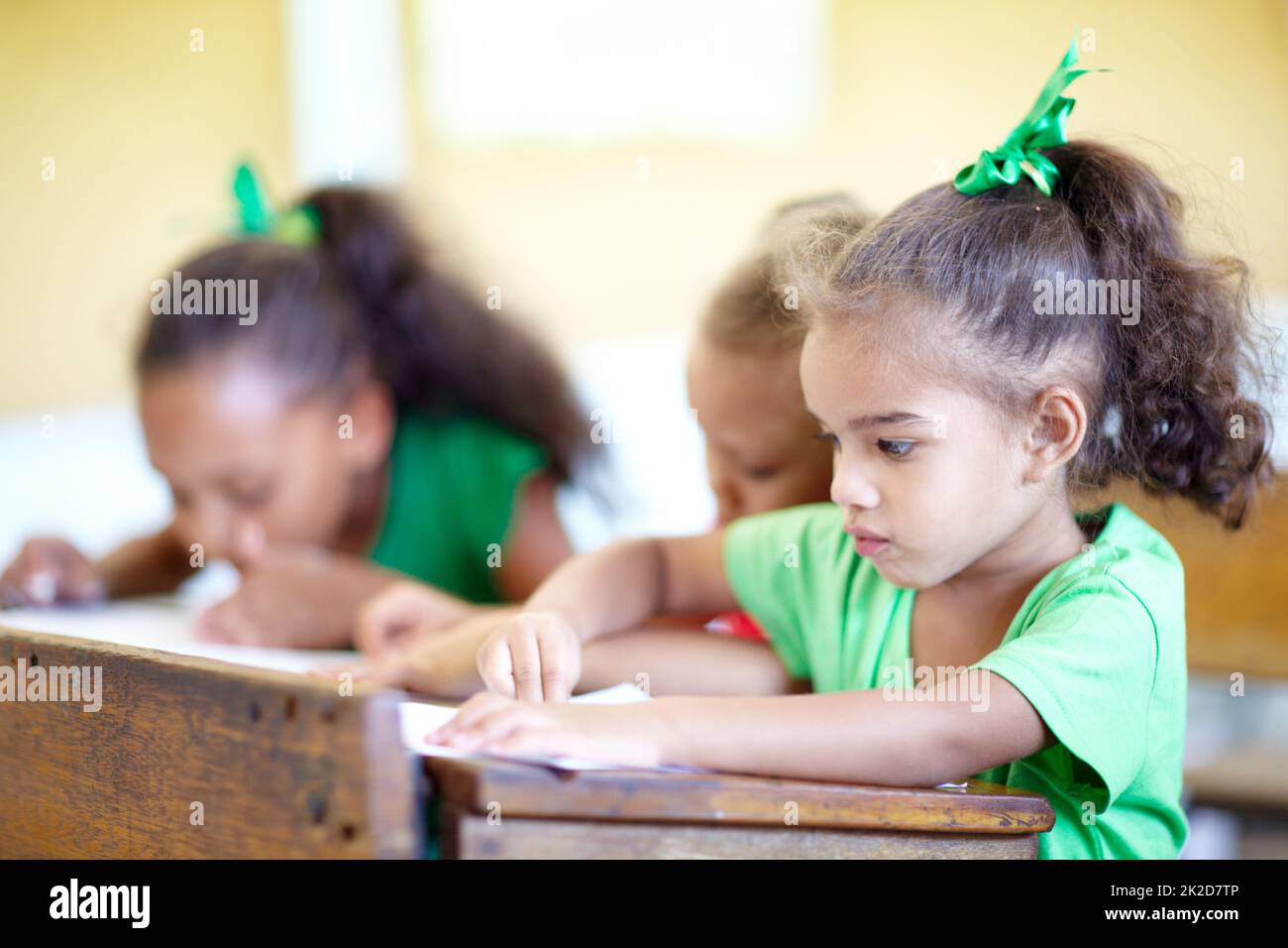 Desideroso di lavorare e imparare - giovani menti. Carino piccoli preschoolers seduti in una classe e disegnare insieme. Foto Stock