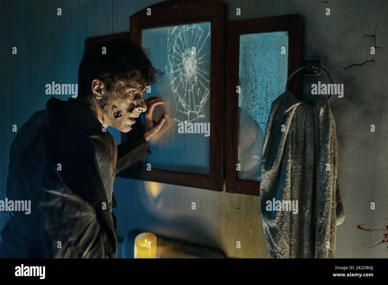 Uomo mostro zombie davanti a specchio rotto Foto Stock