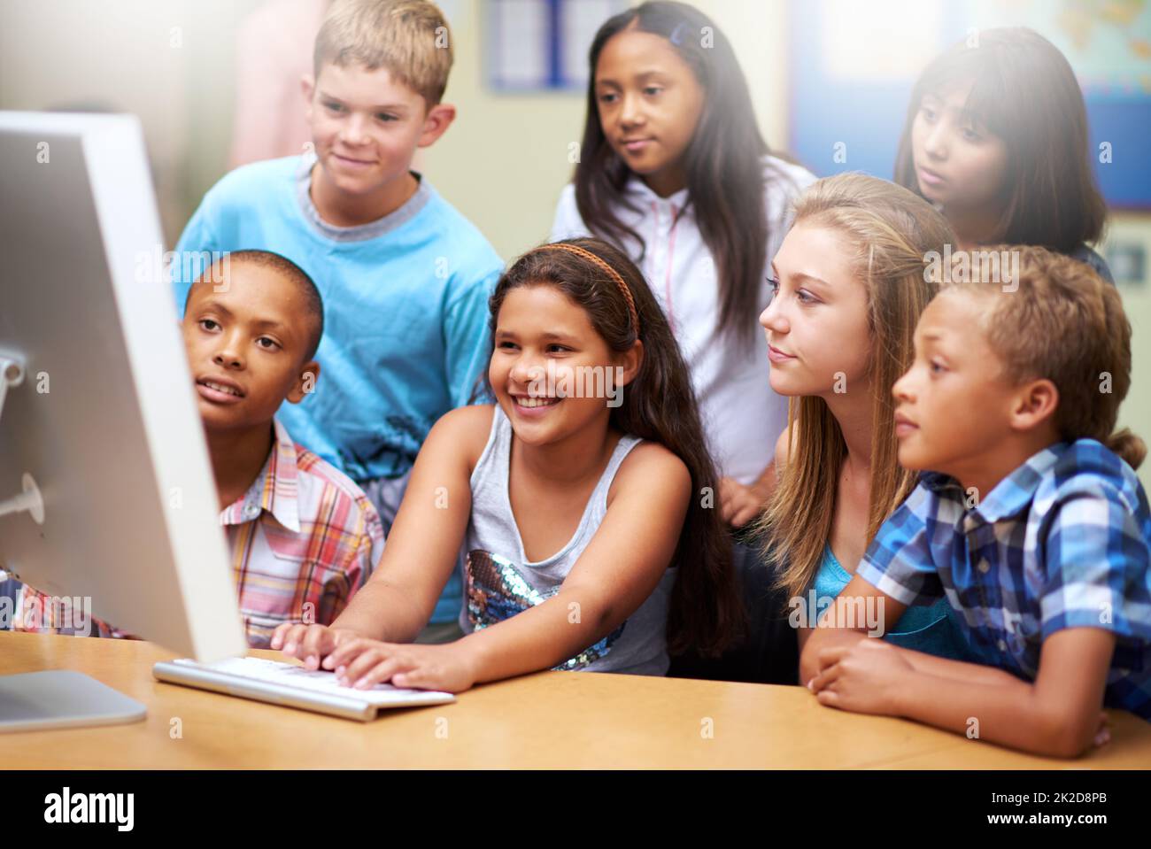 Apprendimento online collaborativo. Un gruppo di alunni che lavorano su un computer in classe. Foto Stock