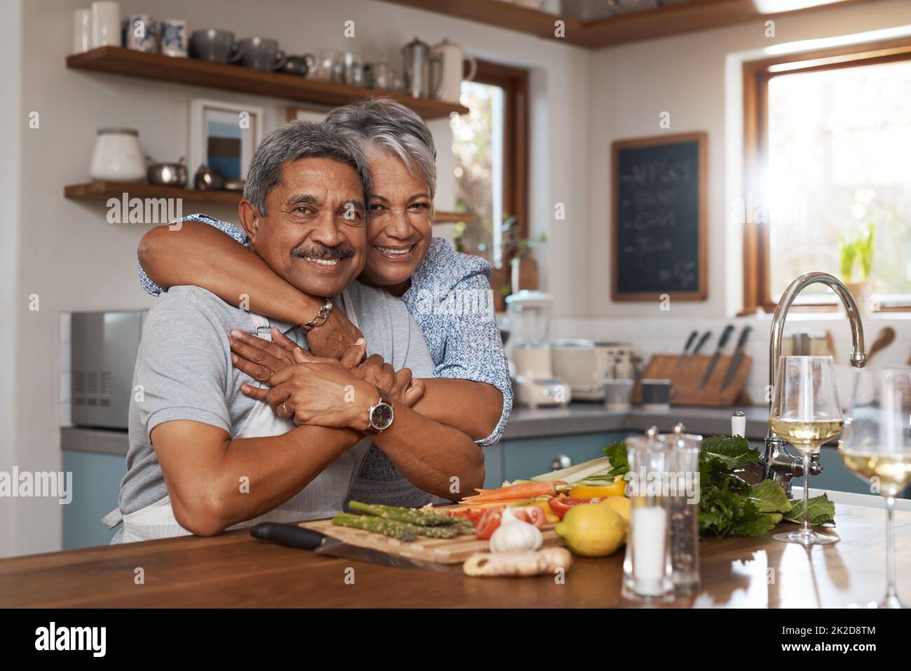 La nostra casa è piena di amore. Ritratto di una coppia matura felice che cucinano un pasto insieme a casa. Foto Stock