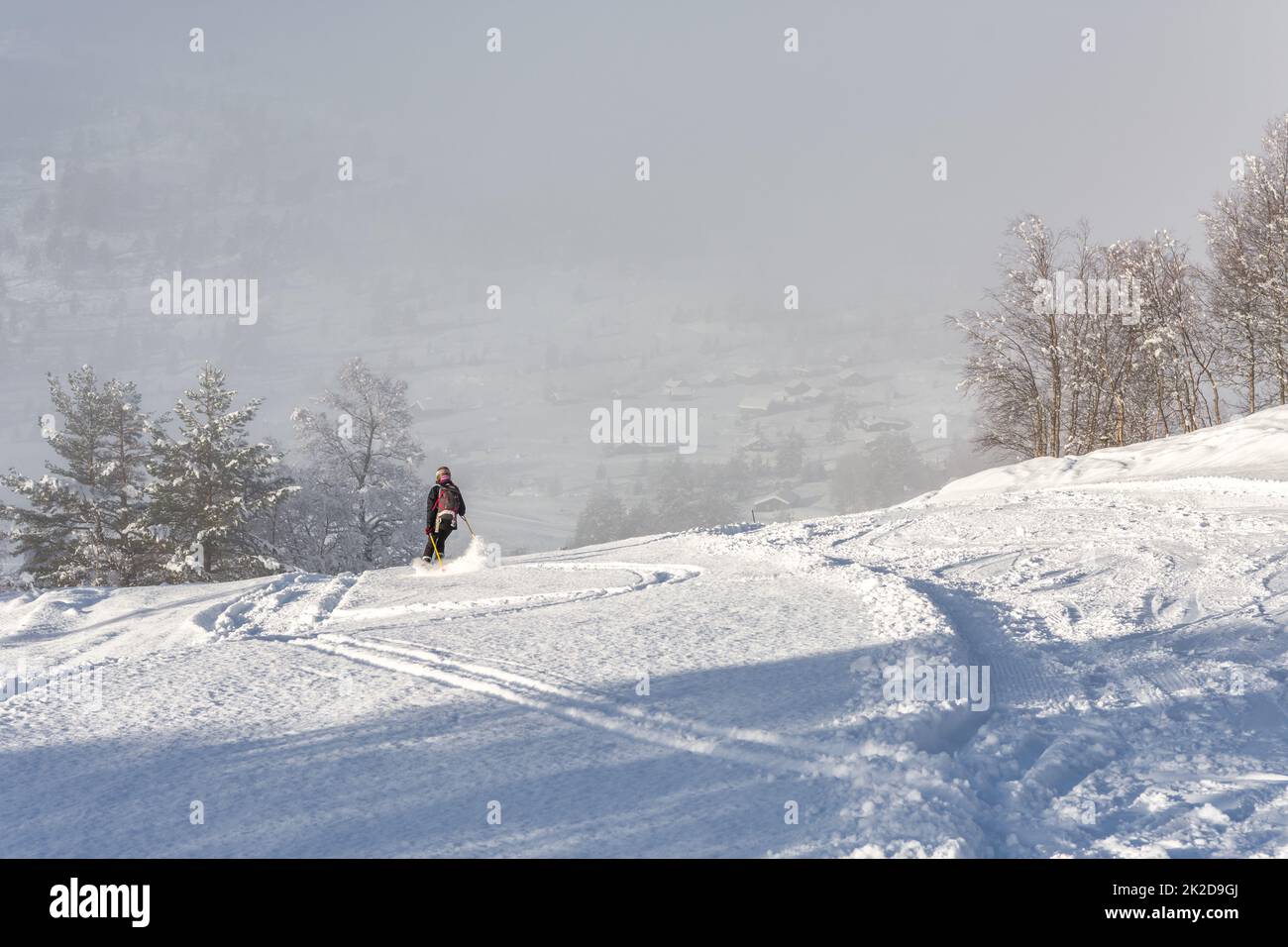 Donna con abbigliamento da sci nero che sciava giù per una montagna in norvegia Foto Stock