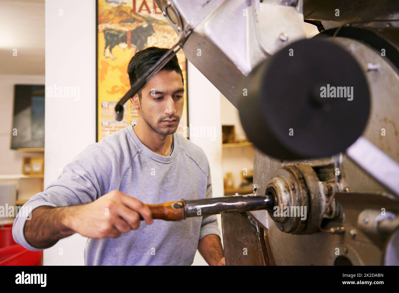 Perfezionare la tostatura. Una macchina per macinare e tostare i chicchi di caffè. Foto Stock