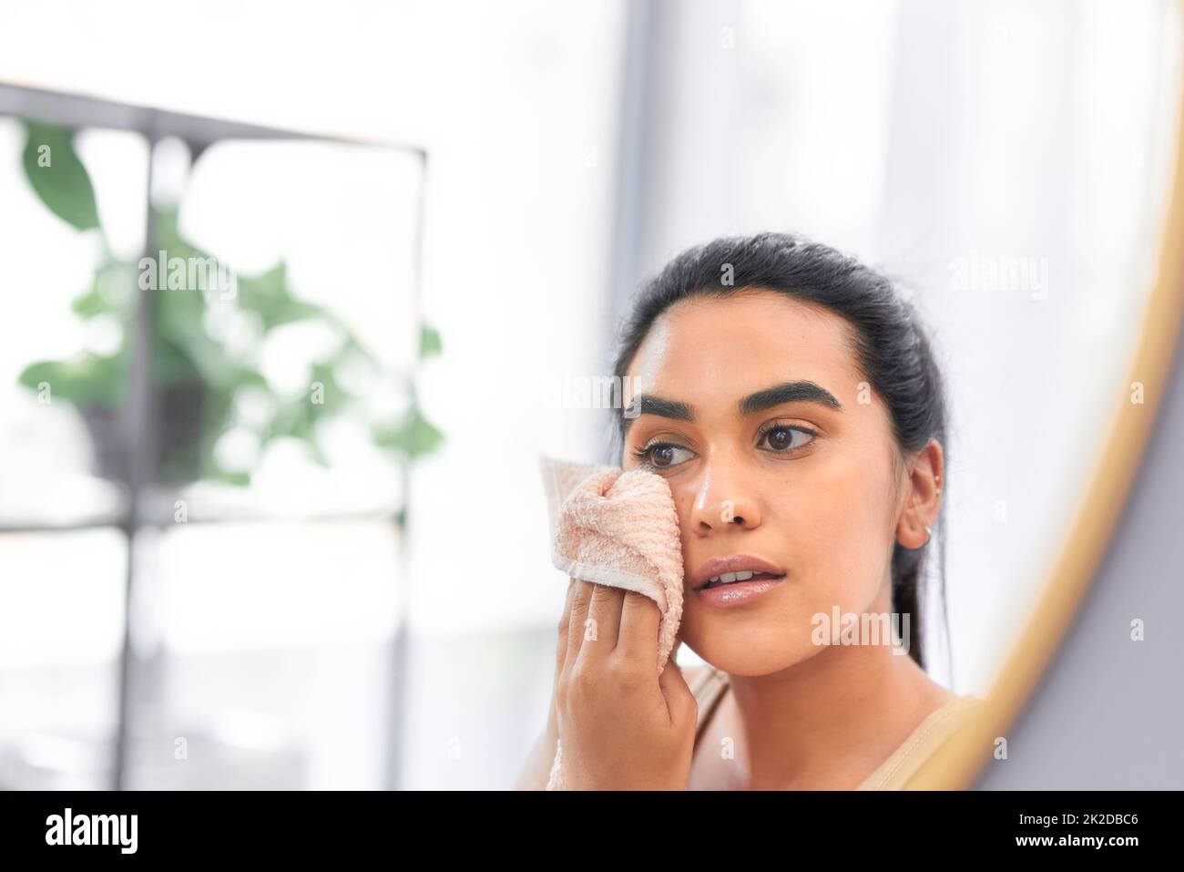 Una cosa youll mai dimenticarlo prendendosi cura della vostra pelle. Scatto di una giovane donna che asciuga il viso con un asciugamano a casa. Foto Stock
