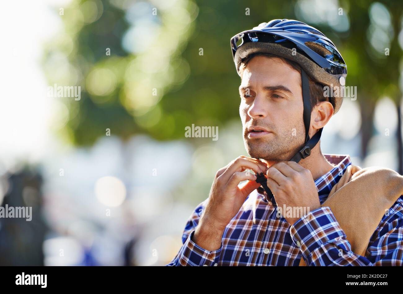Con cinghie per la sicurezza. Scatto di un bel giovane che si prepara a fare un giro indossando un casco. Foto Stock