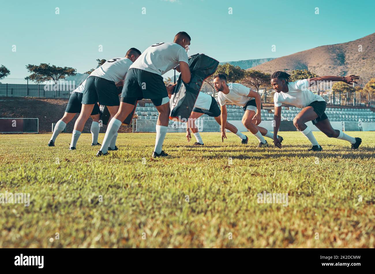 Dare il loro tutto alla pratica di rugby. Shot di un gruppo di giocatori di rugby che si allenano con le borse da affrontare sul campo. Foto Stock