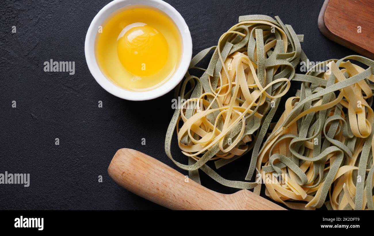 Pasta all'uovo italiana non cotta fatta in casa con spinaci affiancati Foto Stock