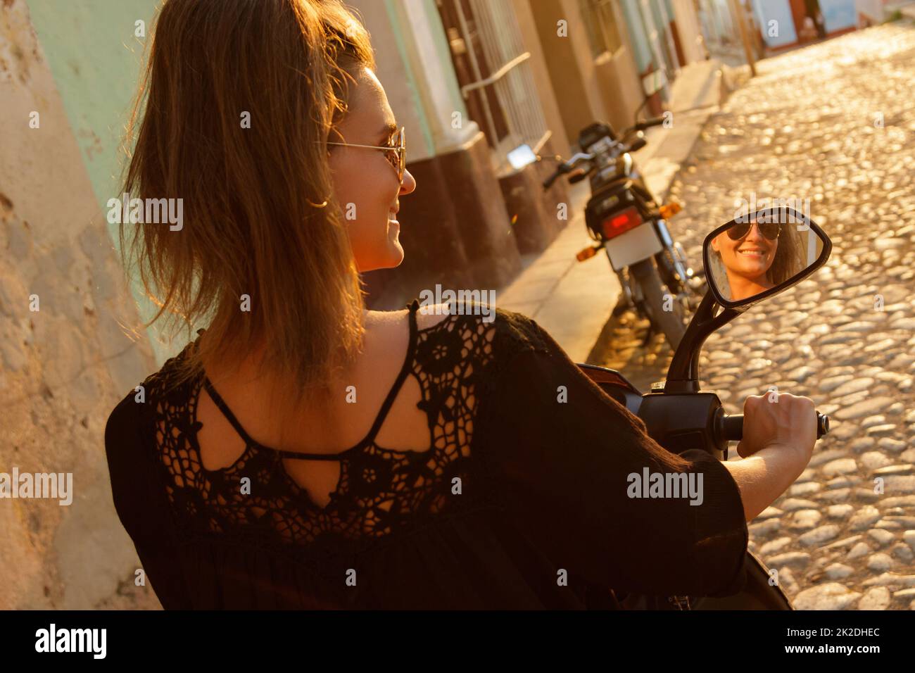 Donna viaggiatore che guida scooter per le strade della città vecchia Foto Stock