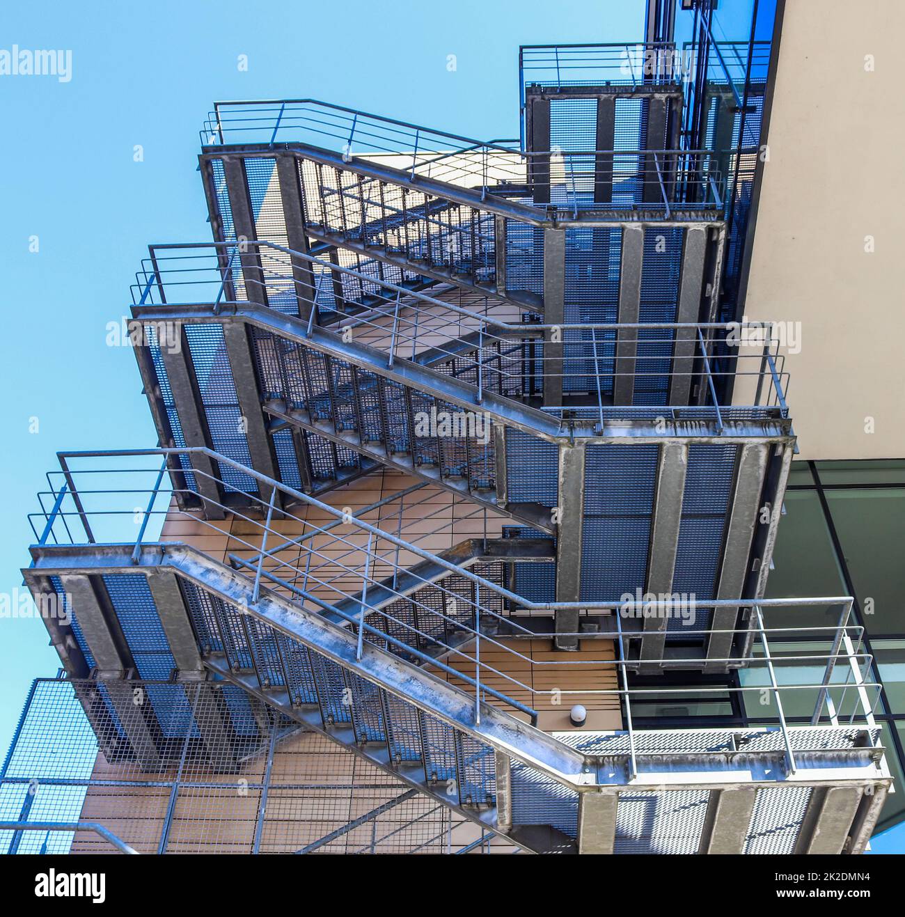 Grandi scale metalliche in un edificio di architettura moderna con un cielo blu. Foto Stock