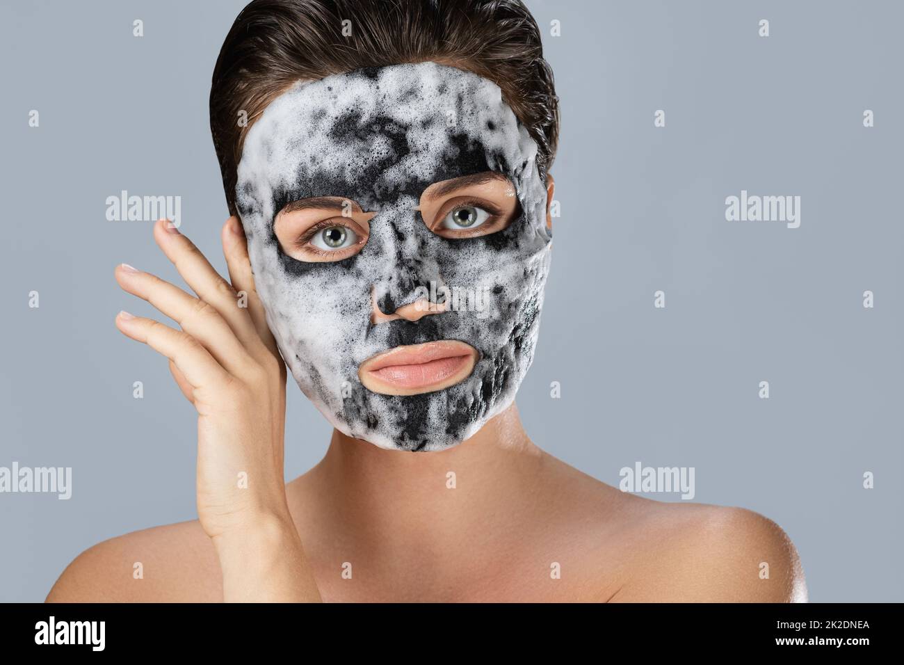 Donna con maschera bolla foglio sul suo viso Foto Stock