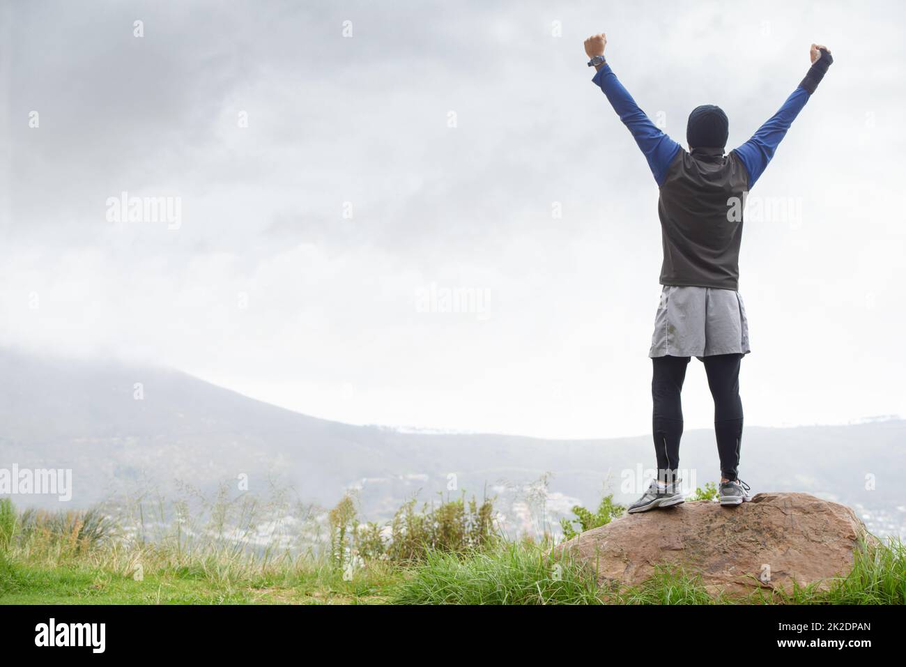 Ive l'ha fatto in cima. Un giovane che festeggia sulla cima di una montagna dopo il reachin. Foto Stock