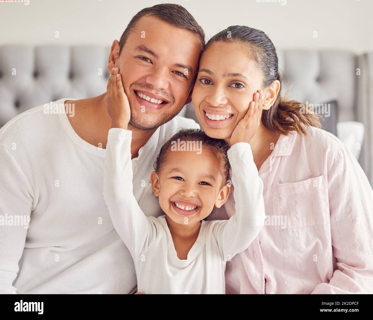 Famiglia felice, la mattina legame e l'amore da bambino con madre e padre nella loro camera da letto dopo il risveglio e indossare pigiama. Ritratto dell'uomo, della donna Foto Stock