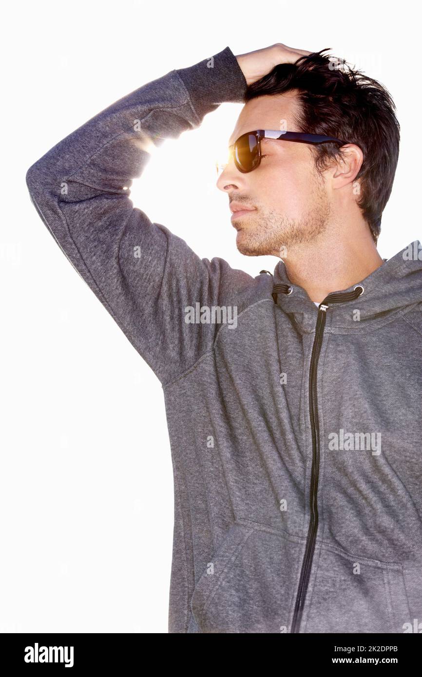 Estate fredda. Basso angolo di un bel giovane uomo che indossa occhiali da sole e che corre la mano attraverso i capelli. Foto Stock