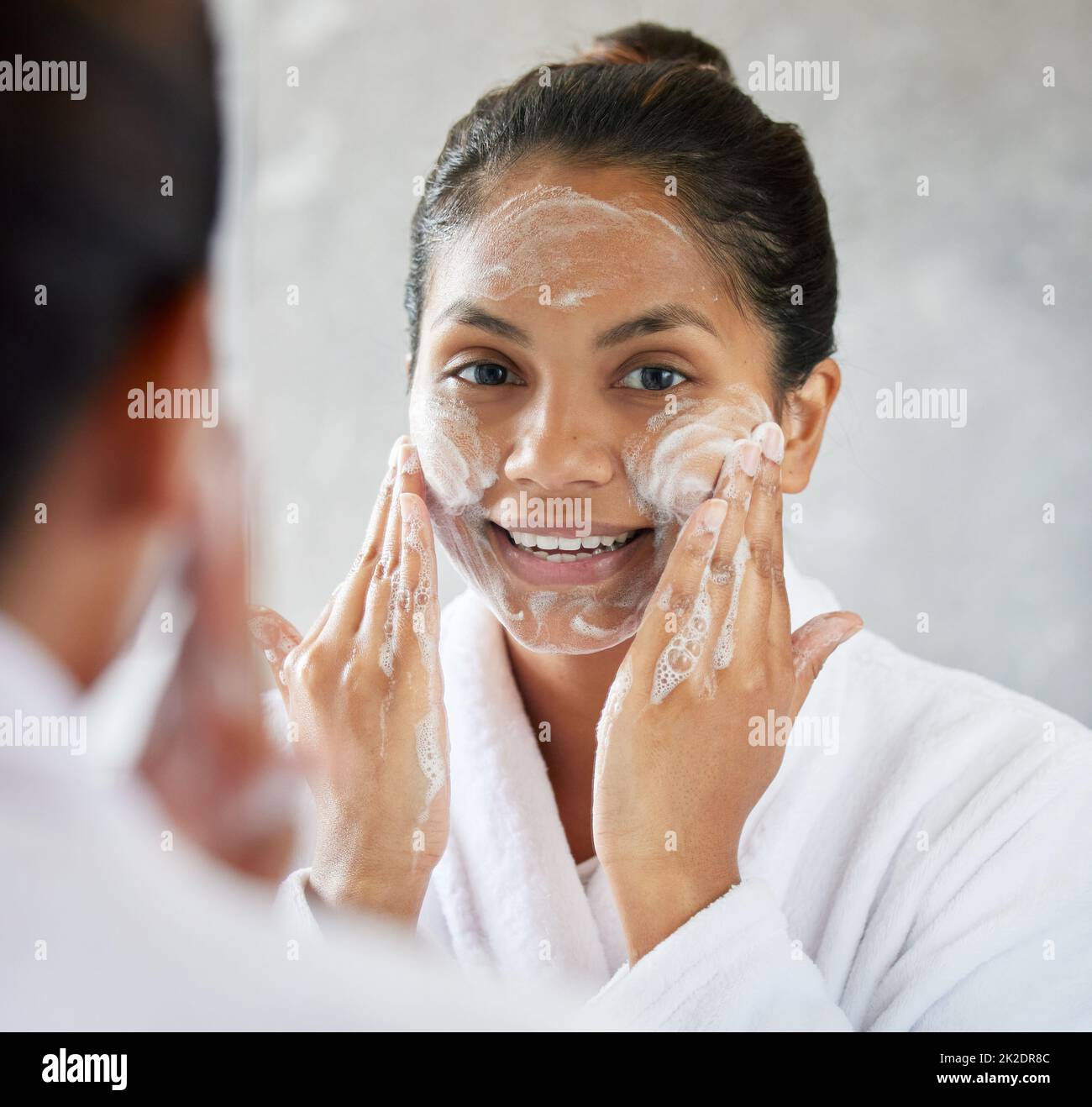 Il trucco è ARTE, la bellezza è SPIRITO. Scatto di giovane donna usando con moisturizer facciale. Foto Stock