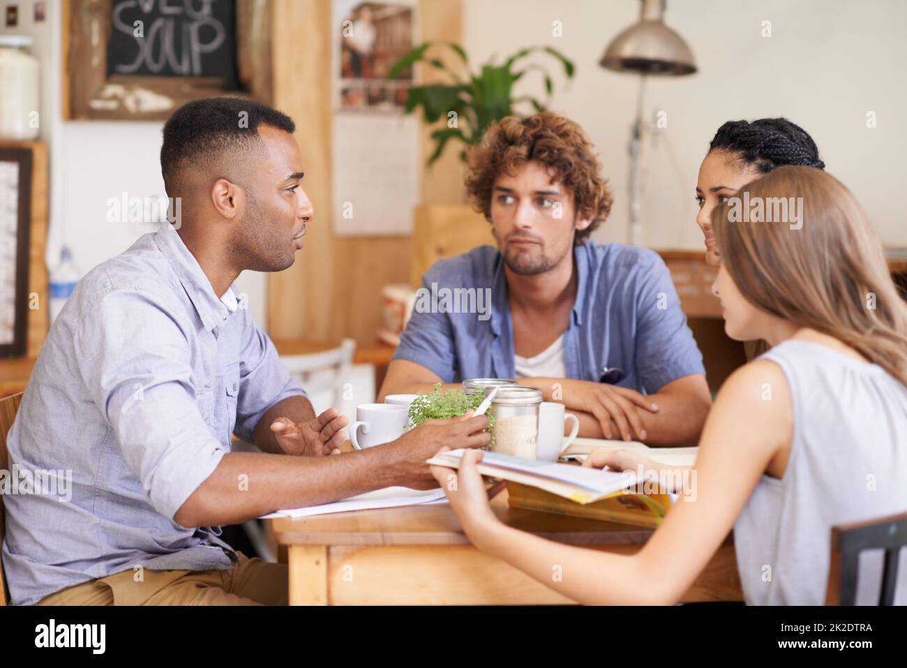 Recuperare con vecchi amici. Foto di un gruppo di amici che parlano in un bar. Foto Stock