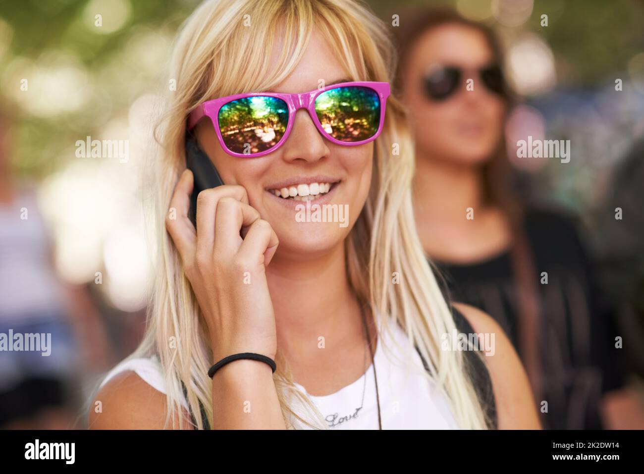 Cercando di entrare in contatto con gli amici al festival. Scatto di una giovane donna che parla su un cellulare in un festival all'aperto. Foto Stock