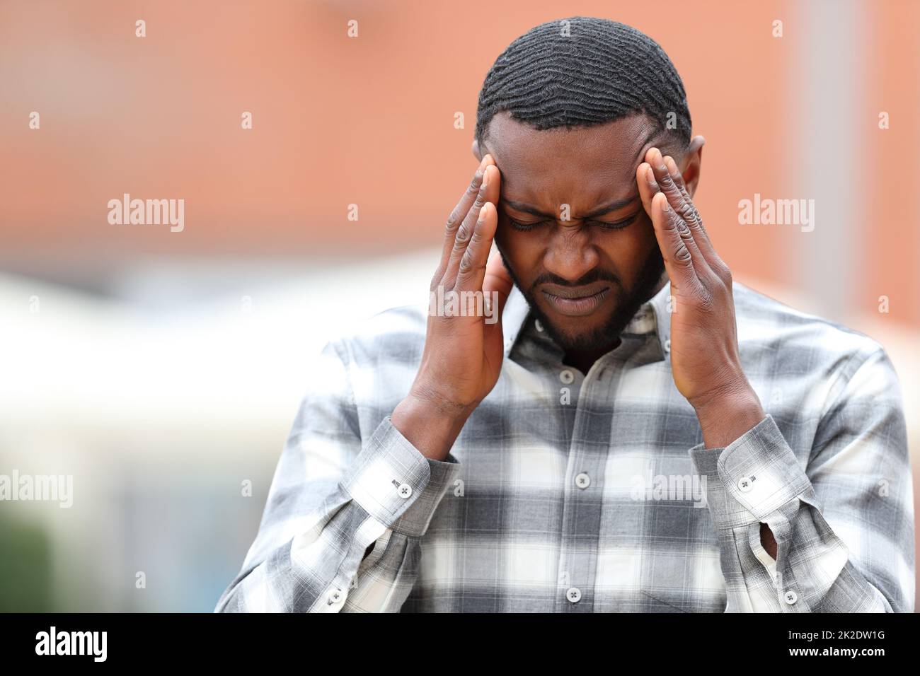 Uomo con pelle nera che soffre emicrania nella strada Foto Stock