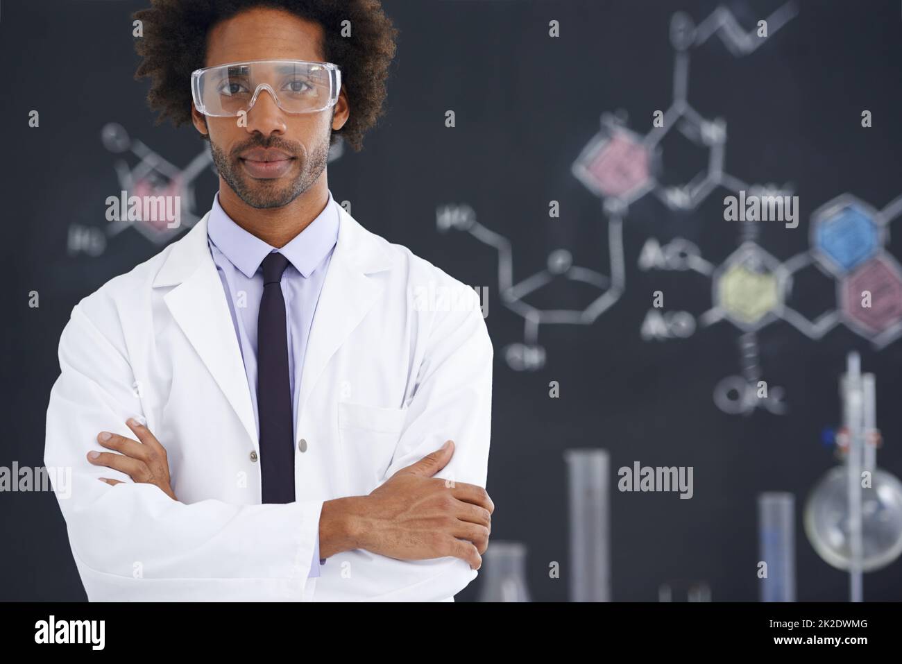 HES aveva sempre una mente analitica. Uno scienziato maschile che si trova di fronte a una lavagna piena di disegni di legami chimici. Foto Stock