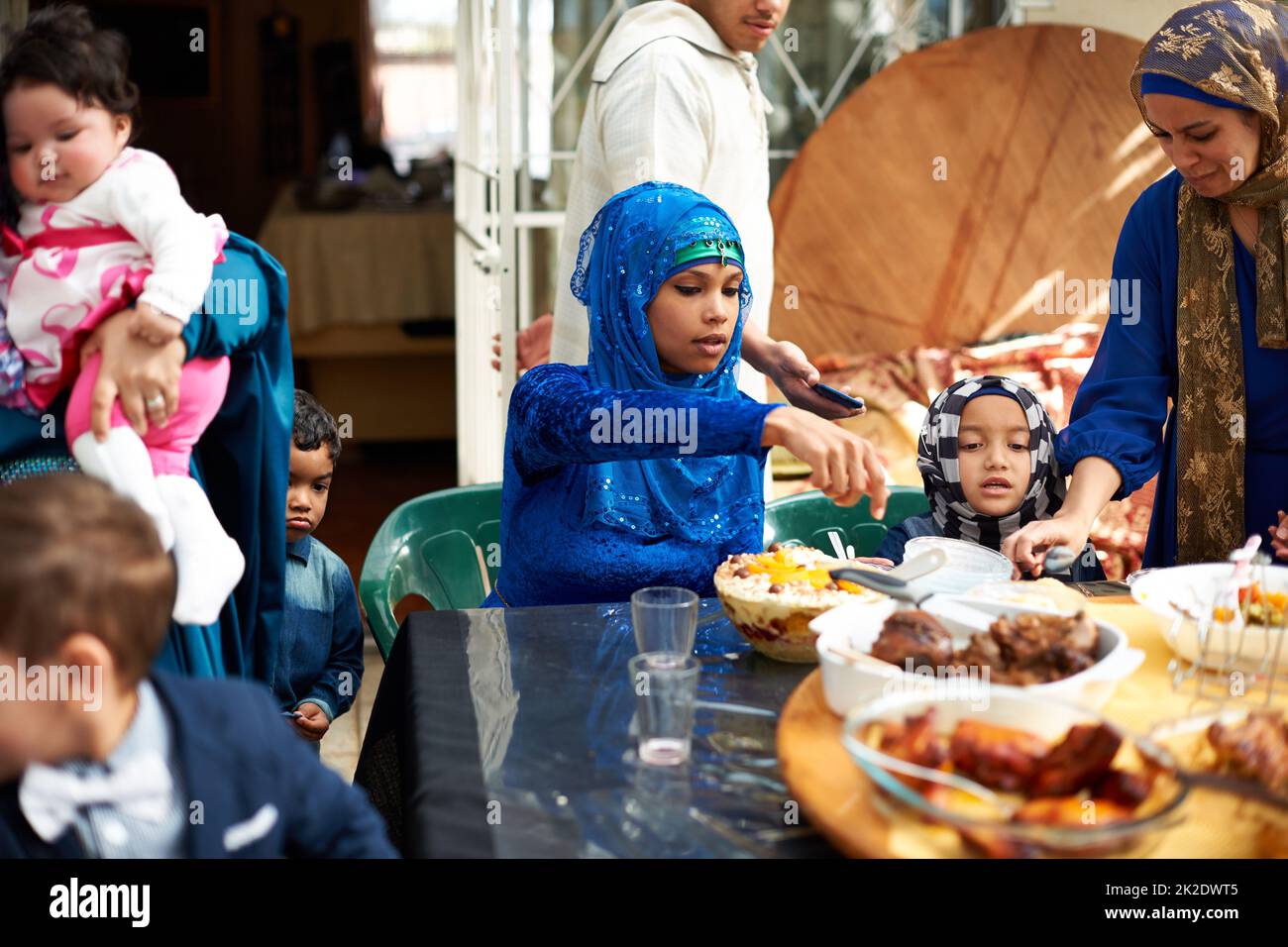 Il cibo riunisce tutti. Shot di una famiglia musulmana che mangia insieme. Foto Stock