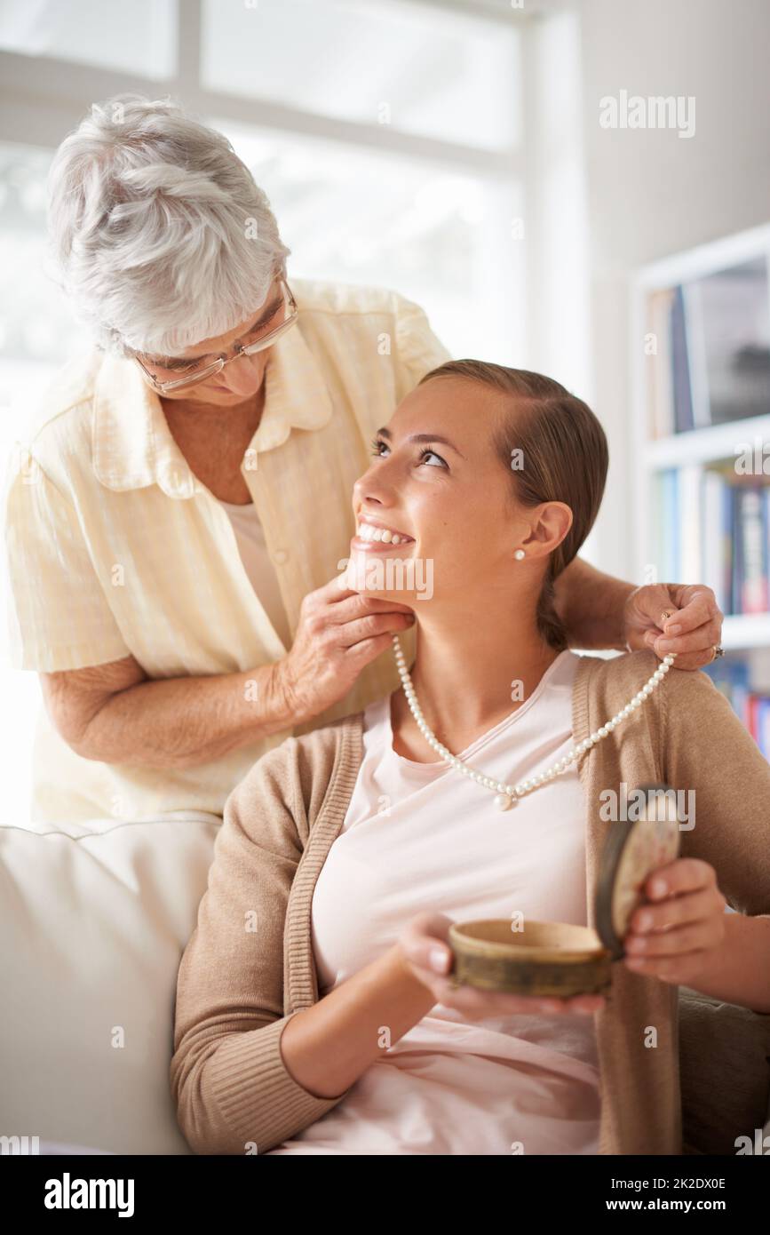 Perle per il mio prezioso. Scatto corto di una donna anziana che dà a sua figlia una collana di perla. Foto Stock