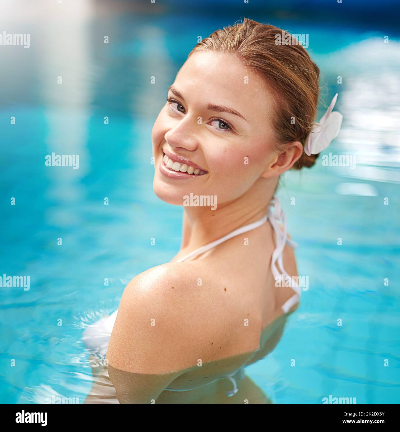 Godendo dei piaceri semplici di una nuotata rilassante. Shot di una giovane donna che si rilassa in piscina presso un centro benessere. Foto Stock