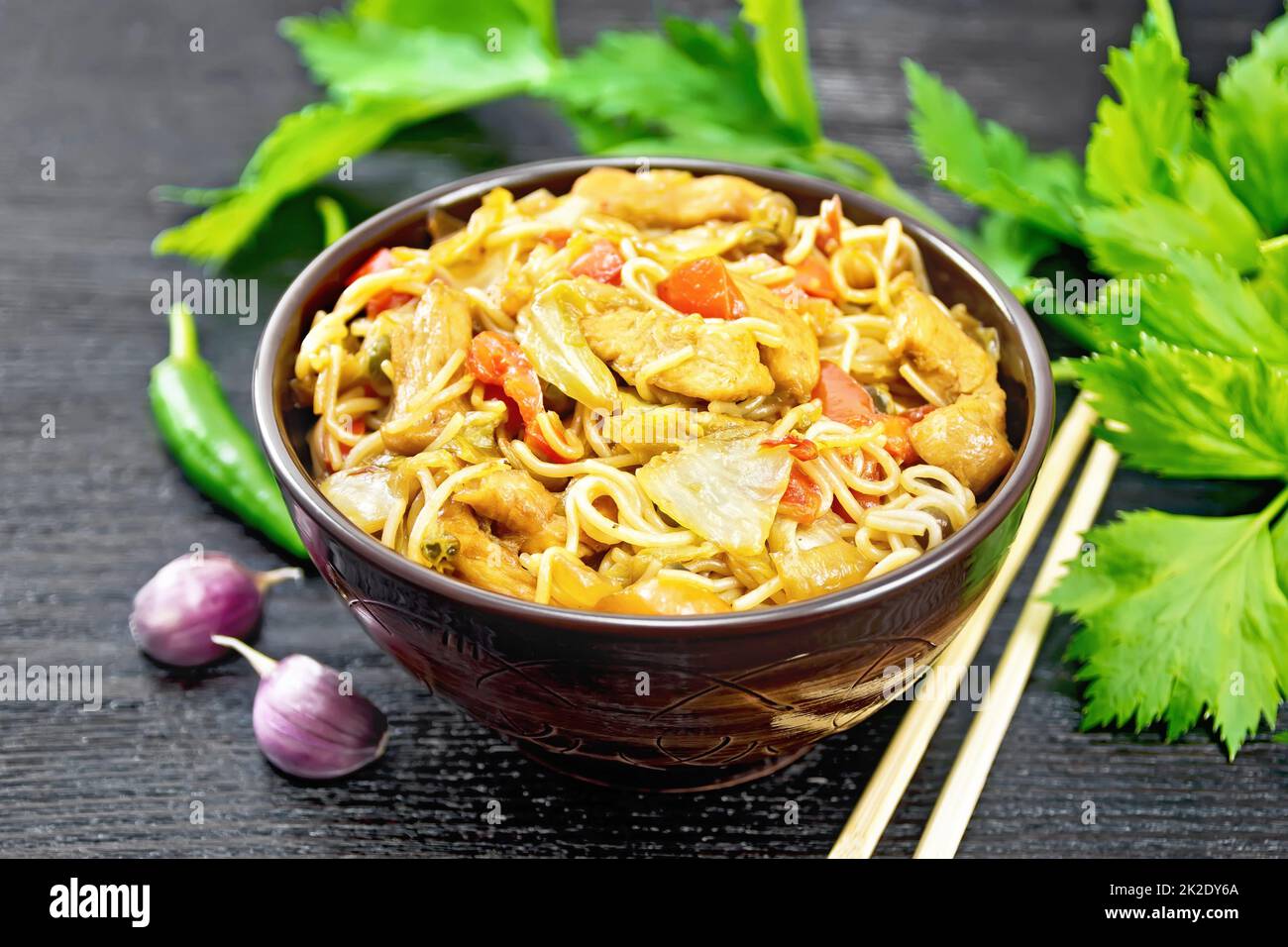 Spaghetti con cavolo e pollo in ciotola su tavola scura Foto Stock