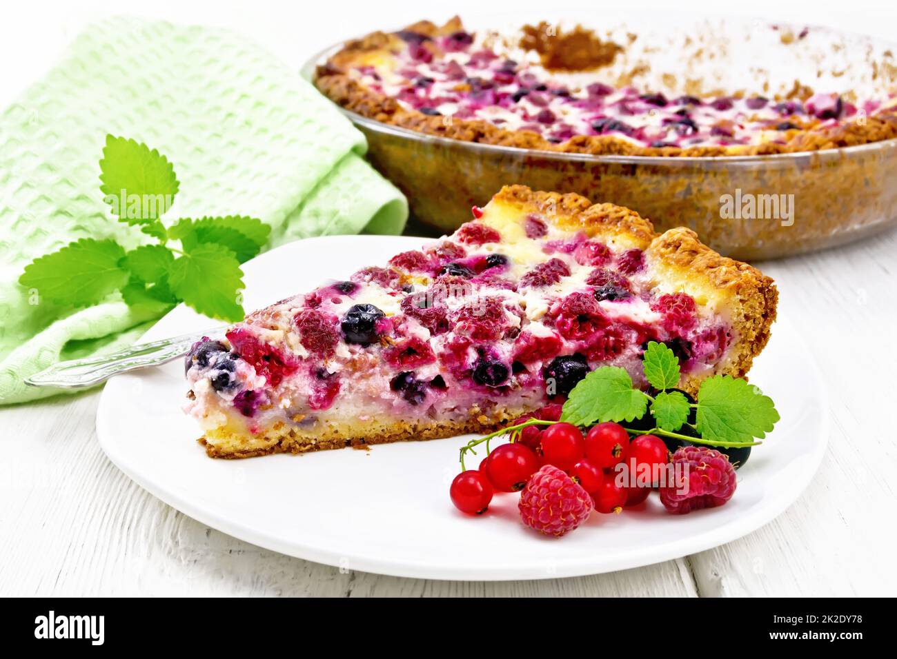 Torta con lamponi e ribes in piatto a bordo Foto Stock