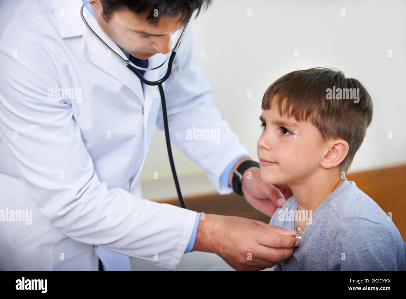 Mettere su un volto coraggioso. Scatto corto di un medico che ascolta il battito cardiaco dei suoi pazienti. Foto Stock