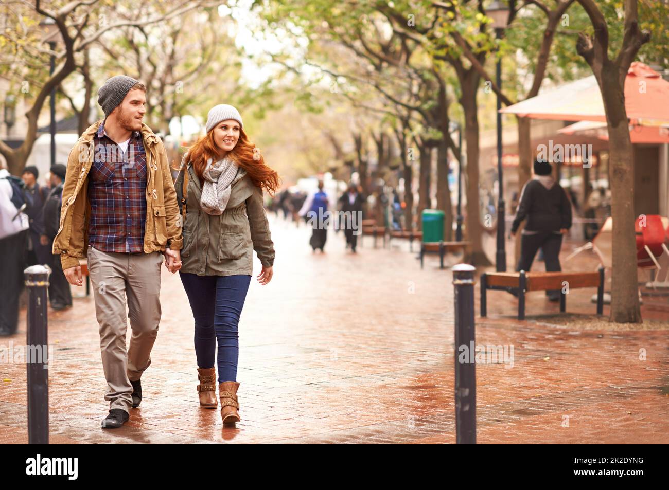 Fare una passeggiata sul lato invernale. Scatto di una giovane coppia felice che cammina attraverso una zona urbana insieme. Foto Stock