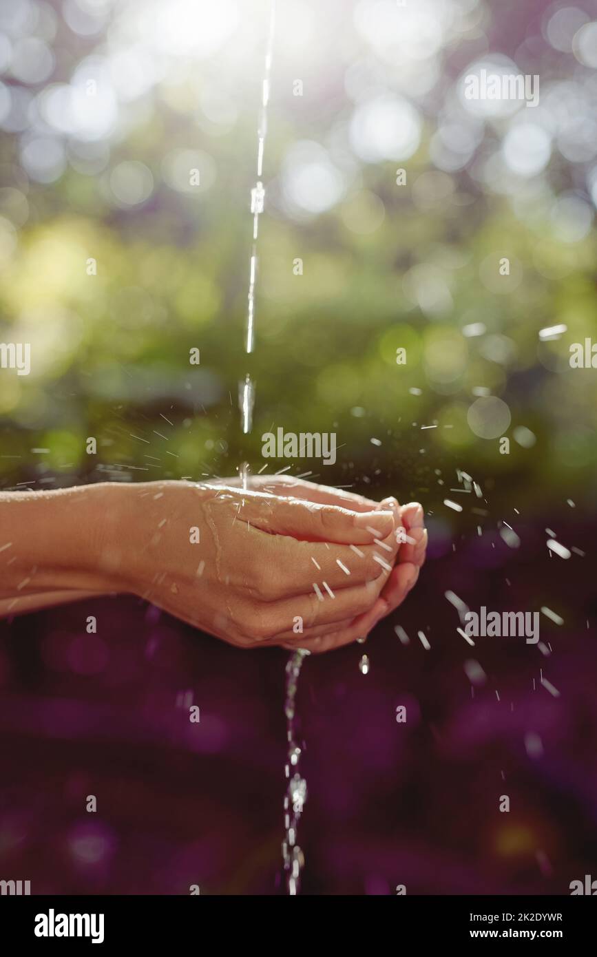 L'acqua e la vita sono una. Scatto ritagliato di una donna che lava le mani all'aperto. Foto Stock