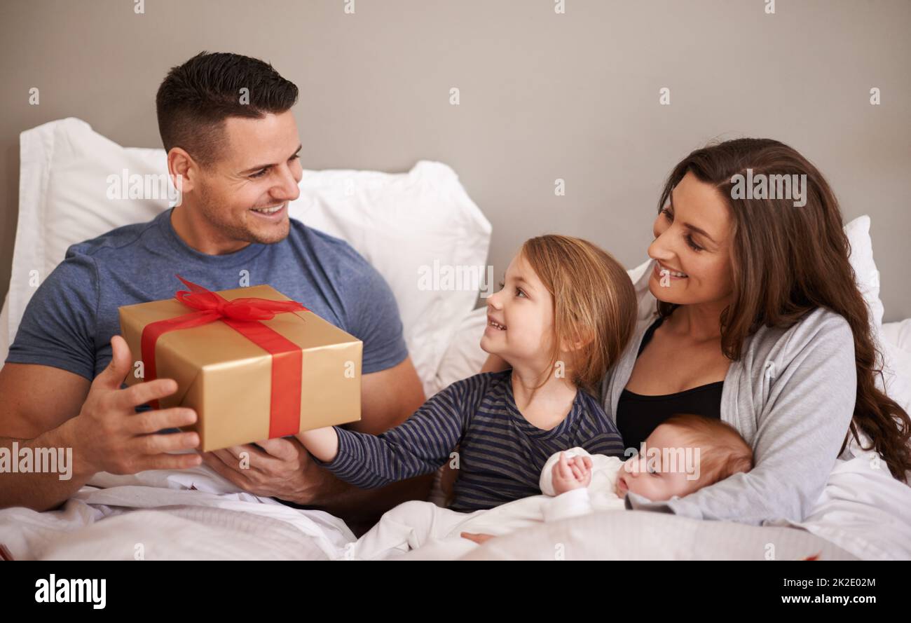 Buon compleanno papà. Scatto di una famiglia felice che dà al loro padre un  regalo nel letto Foto stock - Alamy