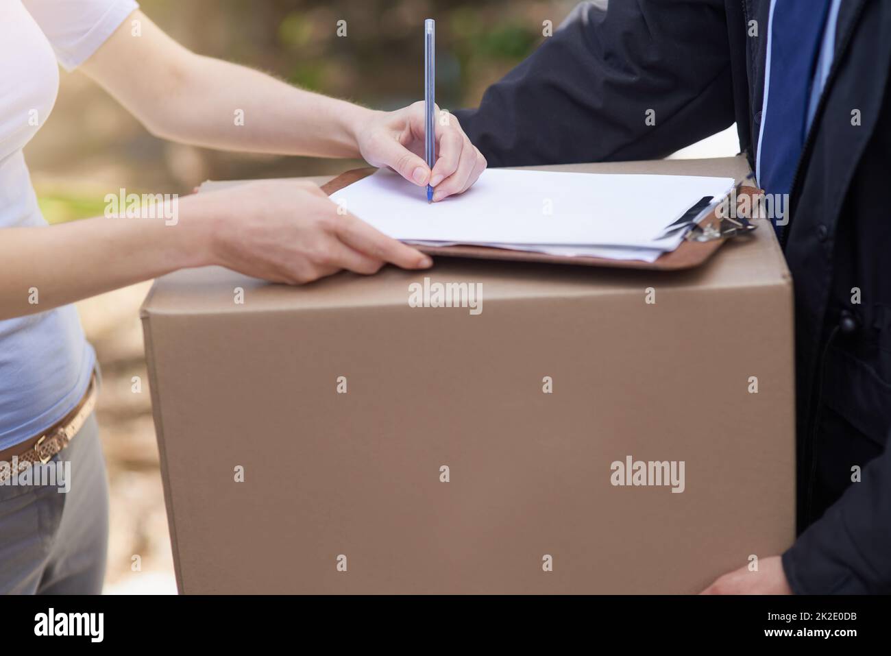 Questo lo rende ufficiale. Colpo di una donna non identificabile che firma per la consegna di un pacco. Foto Stock