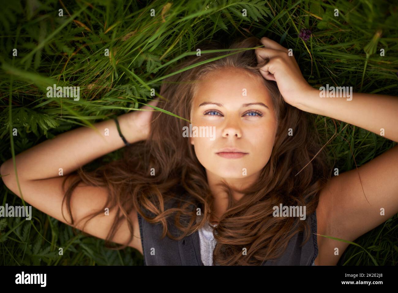 Shes uno con la natura. Ritratto di una splendida donna sdraiata sulla schiena fuori. Foto Stock